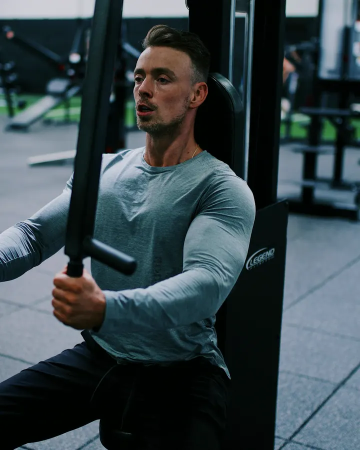 Coach Marcus Cole training on a chest press machine