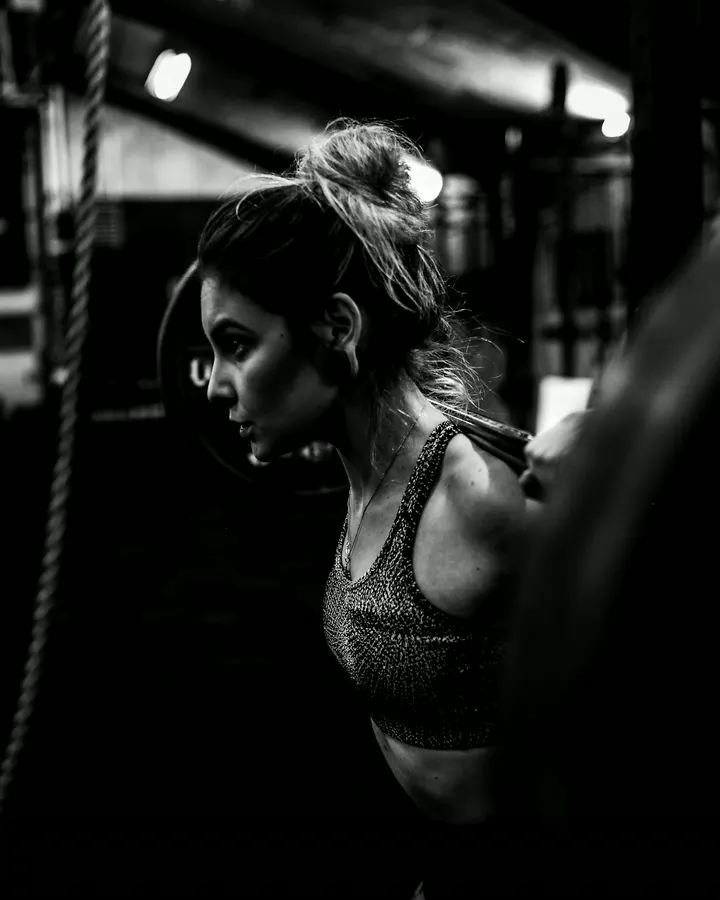 Coach Sasha Lin beside a heavy bag in the boxing room