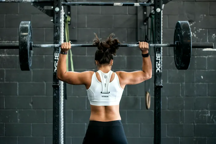 Athlete setting up a back squat in a power rack